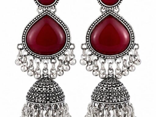 Woman wearing red stone silver jhumka earrings with intricate oxidised silver detailing
