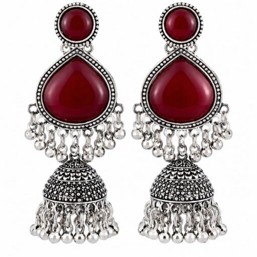 Woman wearing red stone silver jhumka earrings with intricate oxidised silver detailing