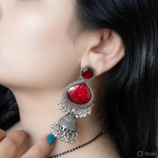 Woman wearing red stone silver jhumka earrings with intricate oxidised silver detailing