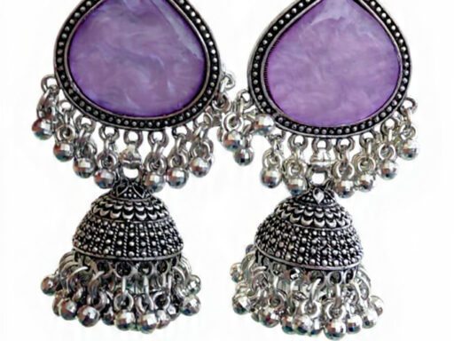 Woman wearing purple stone silver jhumka earrings with intricate oxidised silver detailing